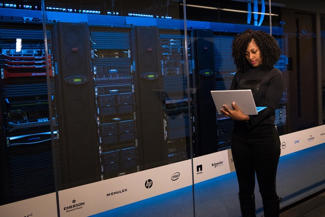 A woman standing outside a data center, which connects to other parts of the business using a WAN