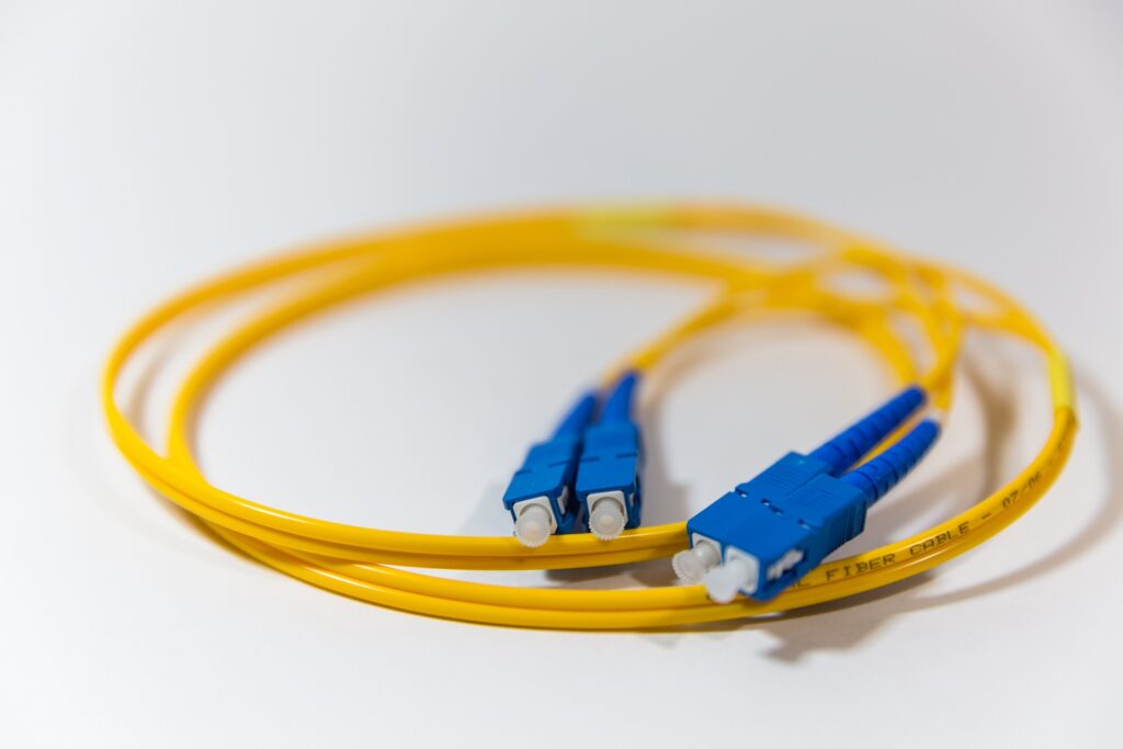 A picture of a yellow Fiber Optic Cable with blue SC Connectors on the ends.